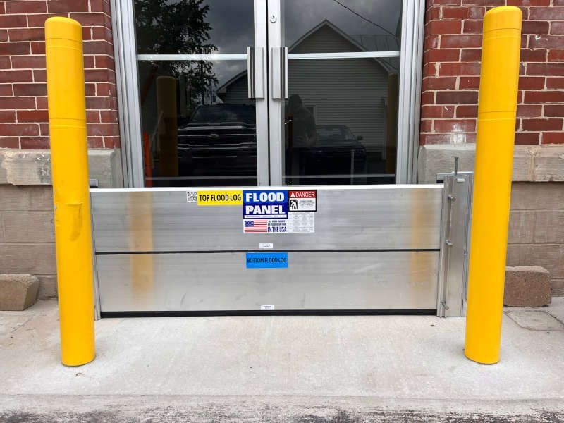 A flood panel is in front of a brick building