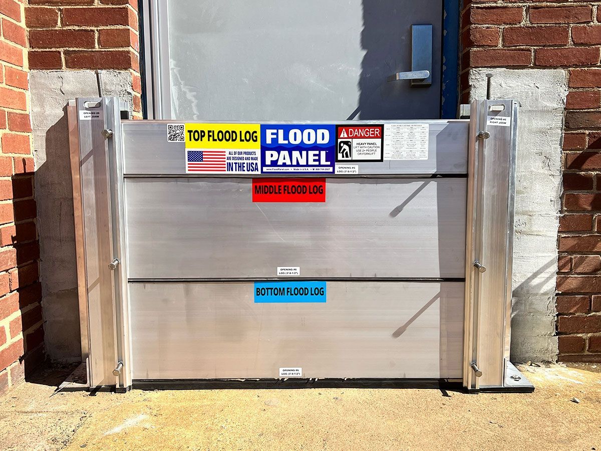 A flood panel is sitting in front of a brick building