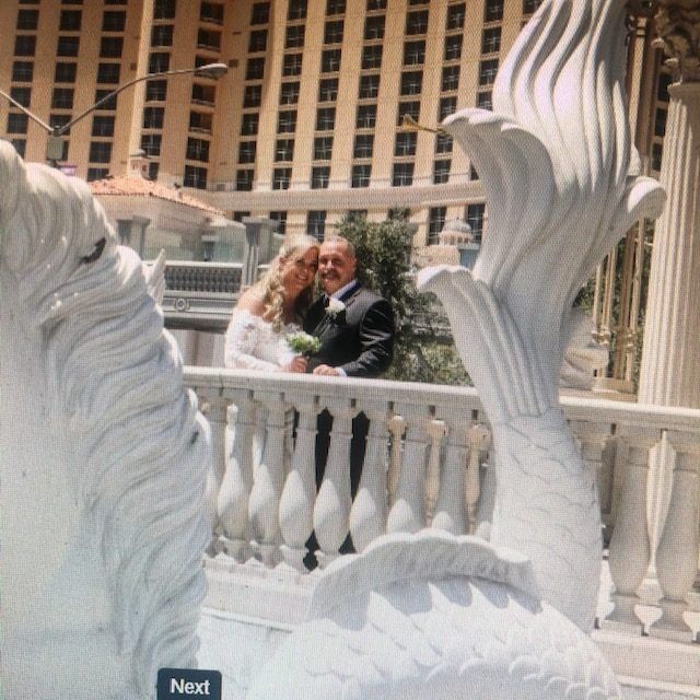 A statue of a bride and groom next to a sign that says next