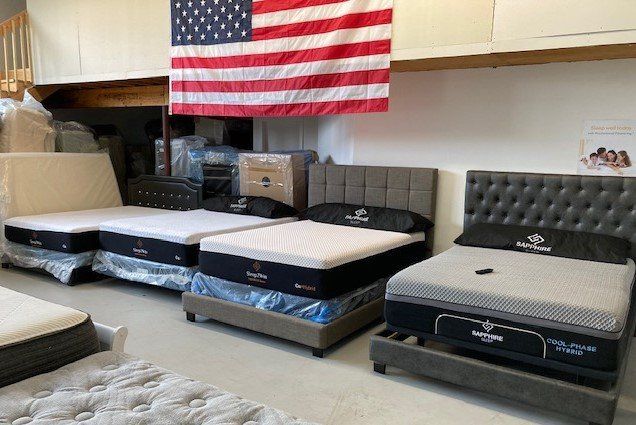 A room filled with mattresses and an american flag.