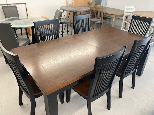 A wooden table with black chairs in a room