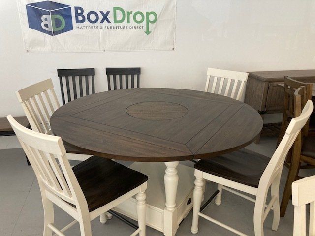 A table and chairs in front of a box drop banner