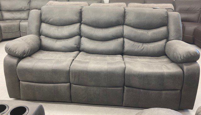 A grey recliner couch is sitting on top of a white floor.
