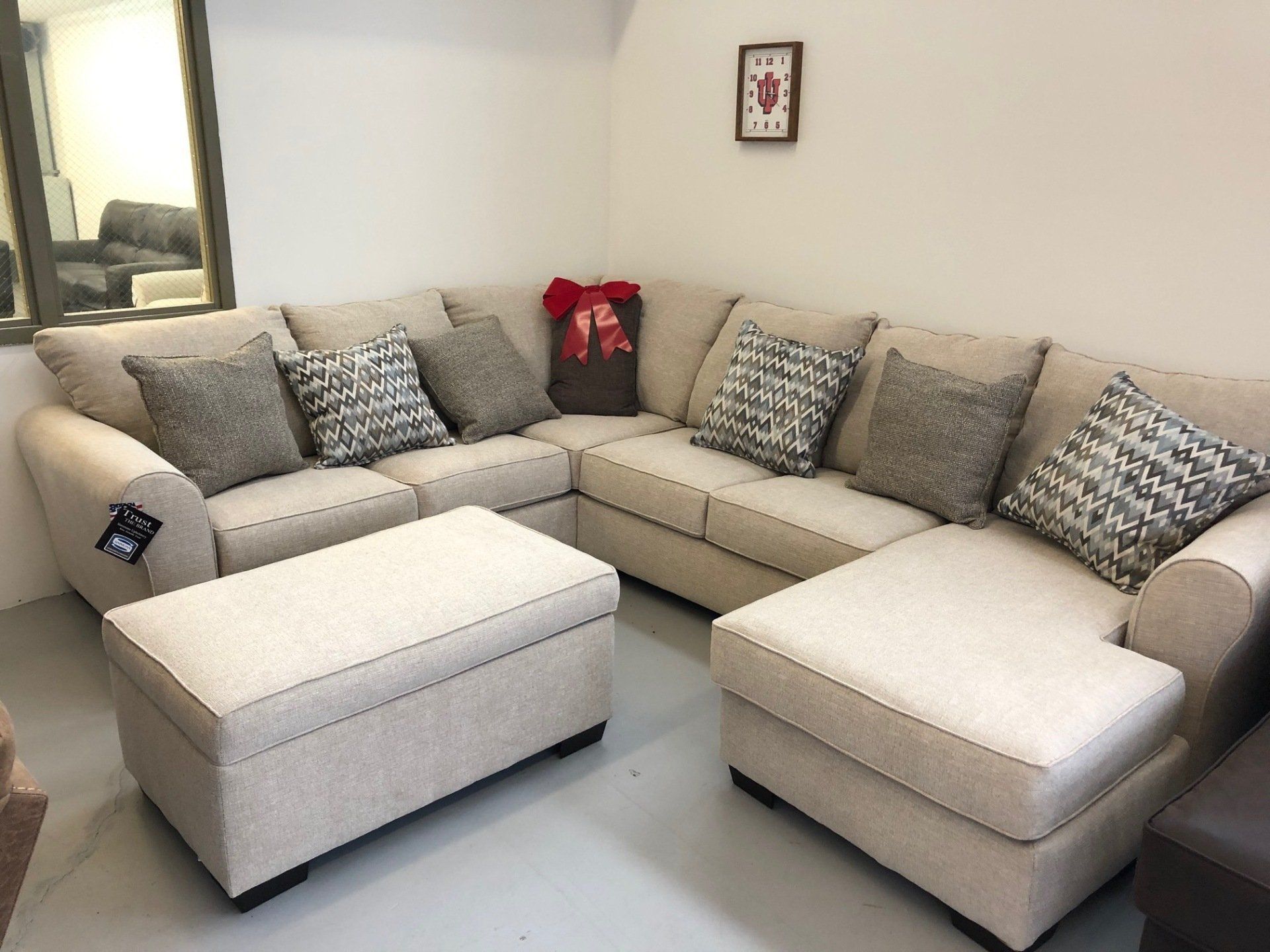 A living room with a sectional couch and ottoman