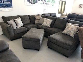 A living room filled with furniture and a large sectional couch.