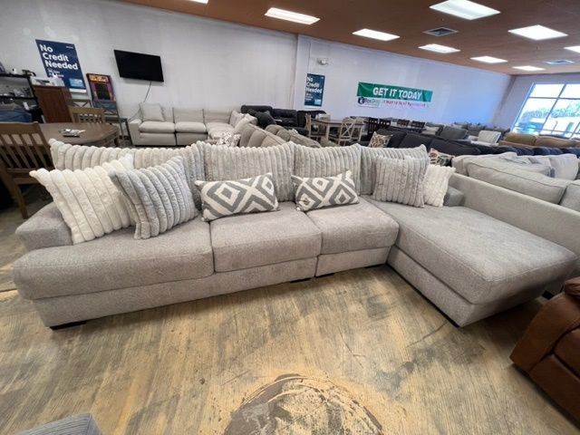 A large sectional couch with lots of pillows in a living room