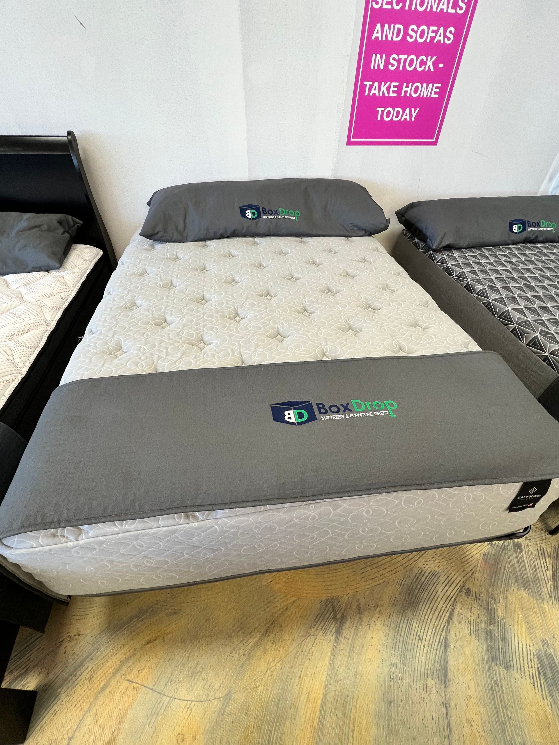 A bed with a mattress and pillows on it in a store.