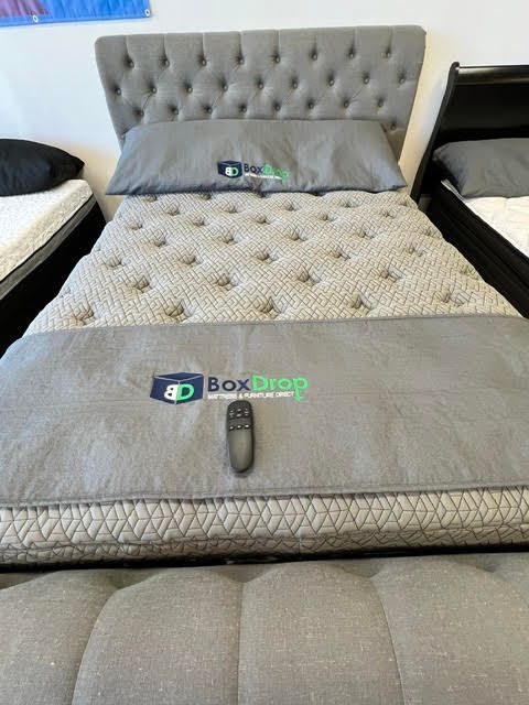 A bed with a box sleep mattress and a remote control on it