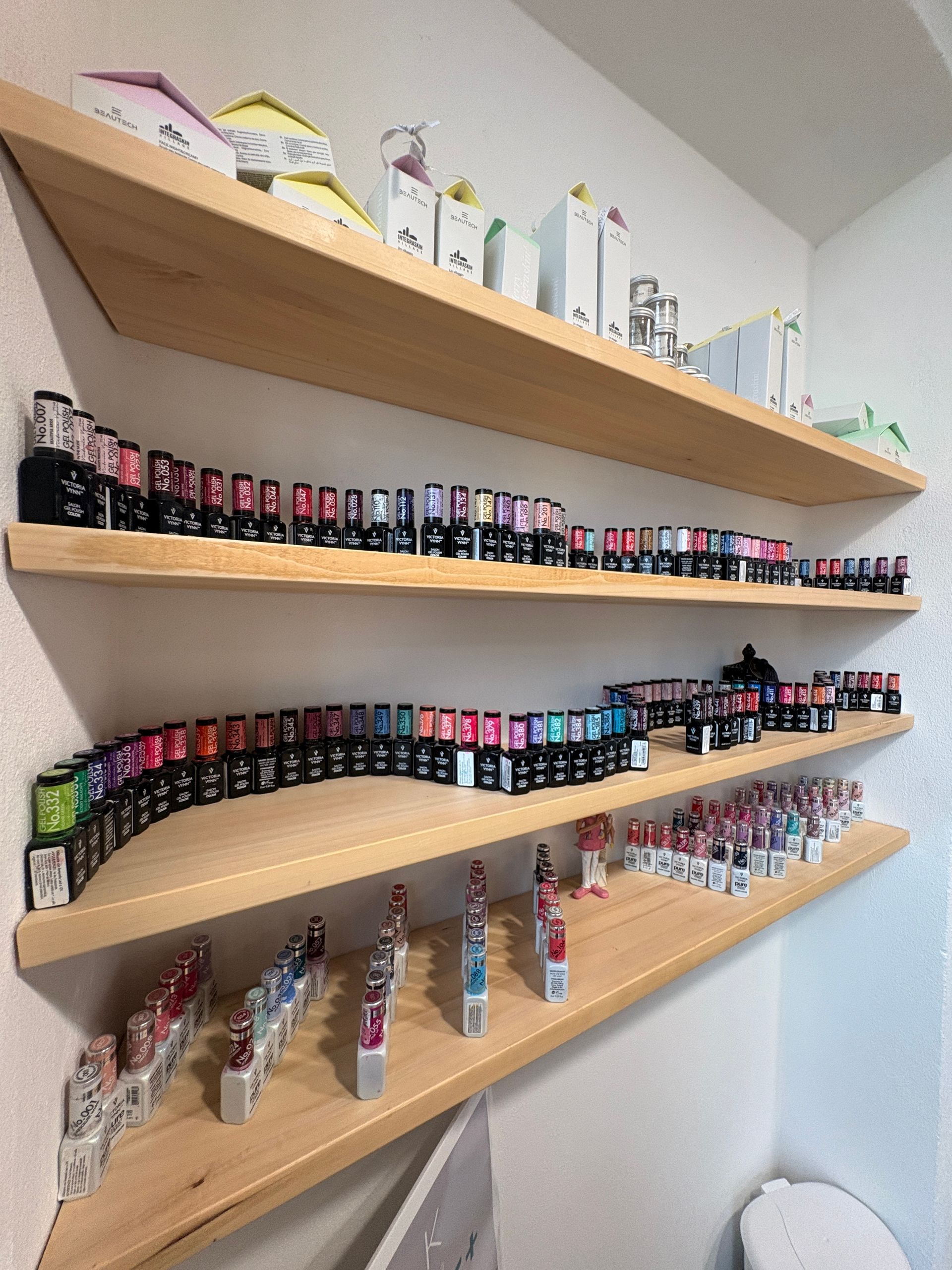 Una mano mostra unghie a mandorla dipinte di rosa, con un'unghia decorata con una stampa leopardata viola e una linea argentata.