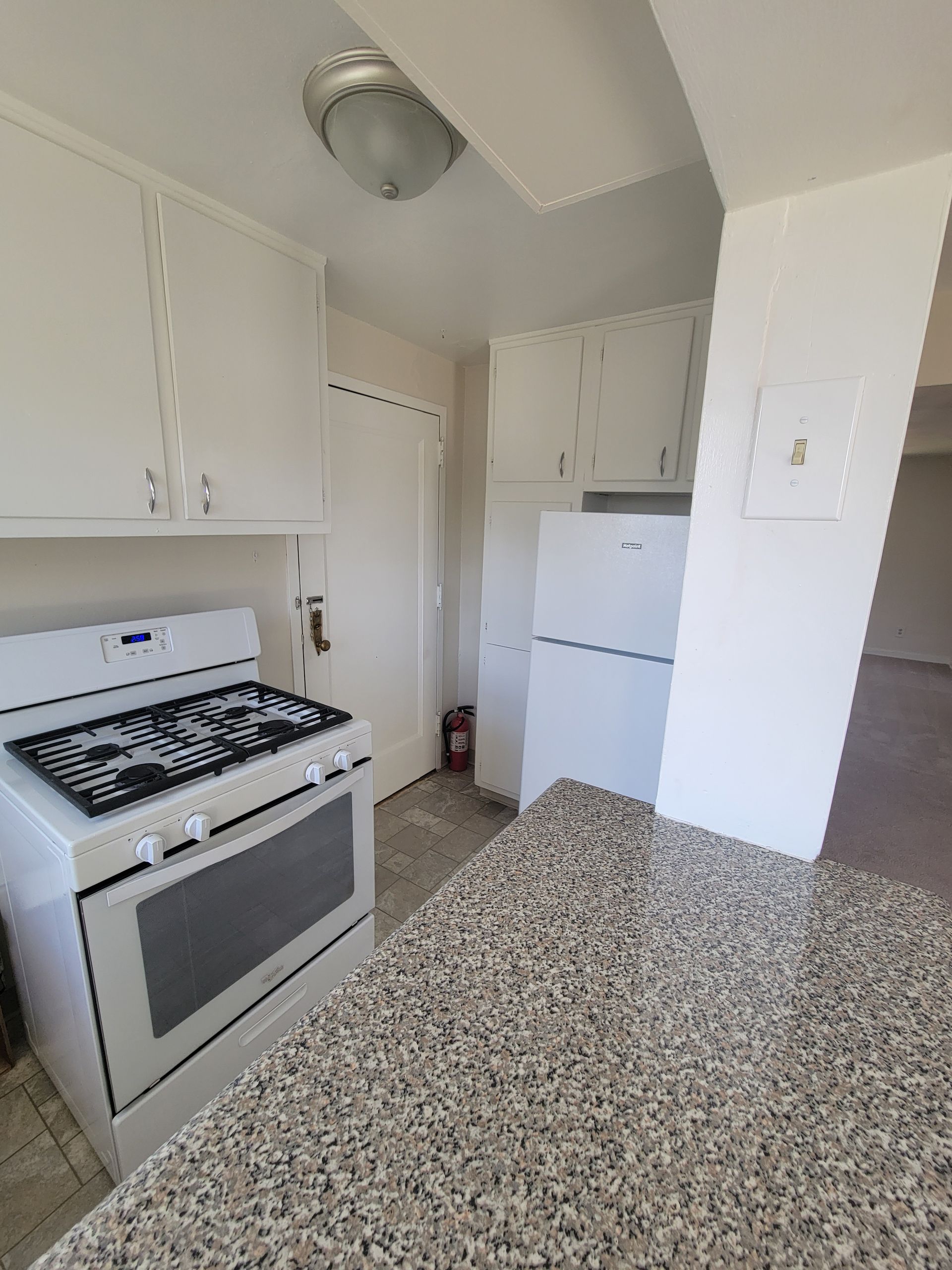 A kitchen with a stove top oven and a refrigerator