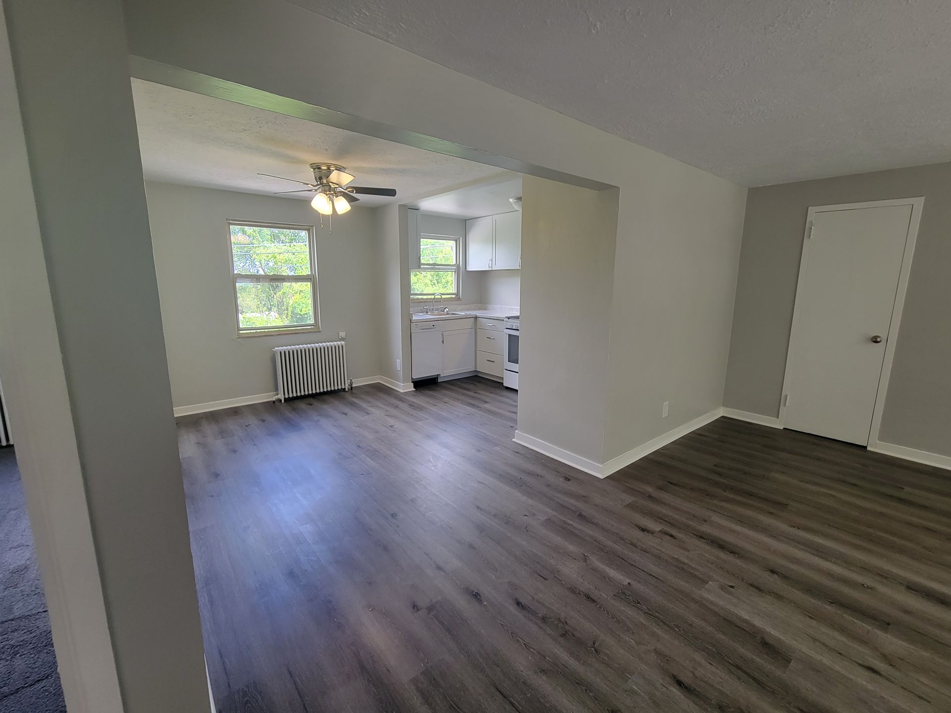 A living room with hardwood floors and a ceiling fan.