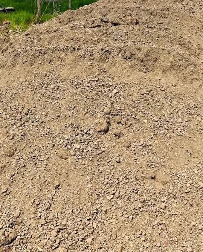 Pile of light brown dirt and gravel, outdoors.