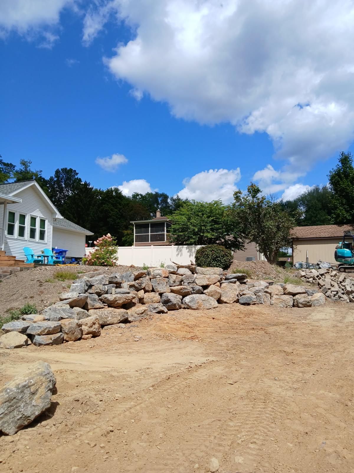 A blue and black snowplow with yellow and orange accents, sitting on an asphalt surface in an outdoor setting.