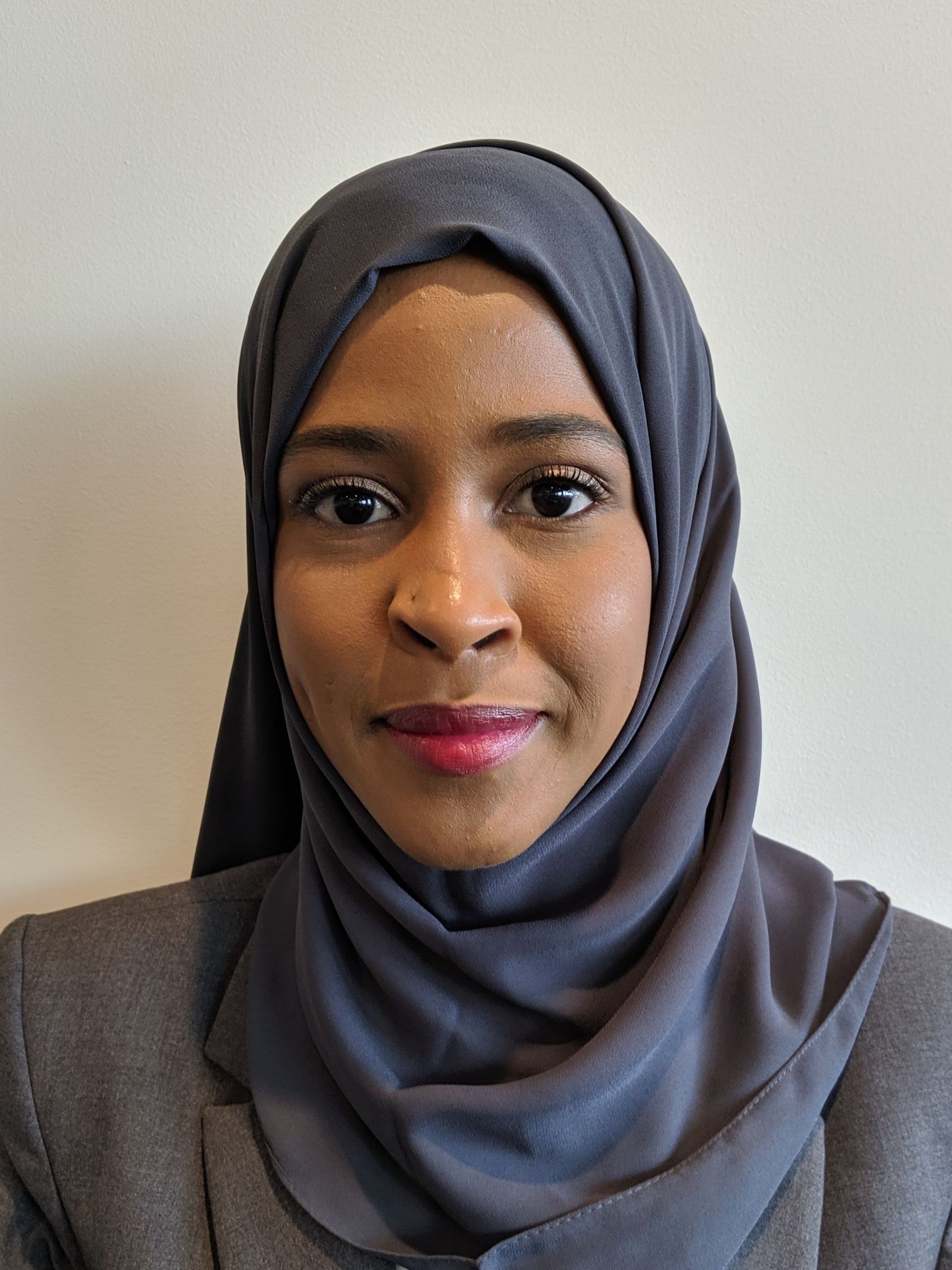 A woman wearing a hijab is looking at the camera.