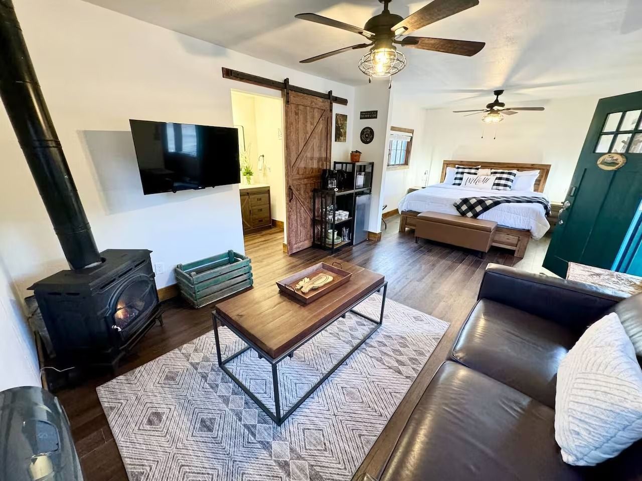 Cozy living space with fireplace, TV, bed, rug, and dark wood accents.
