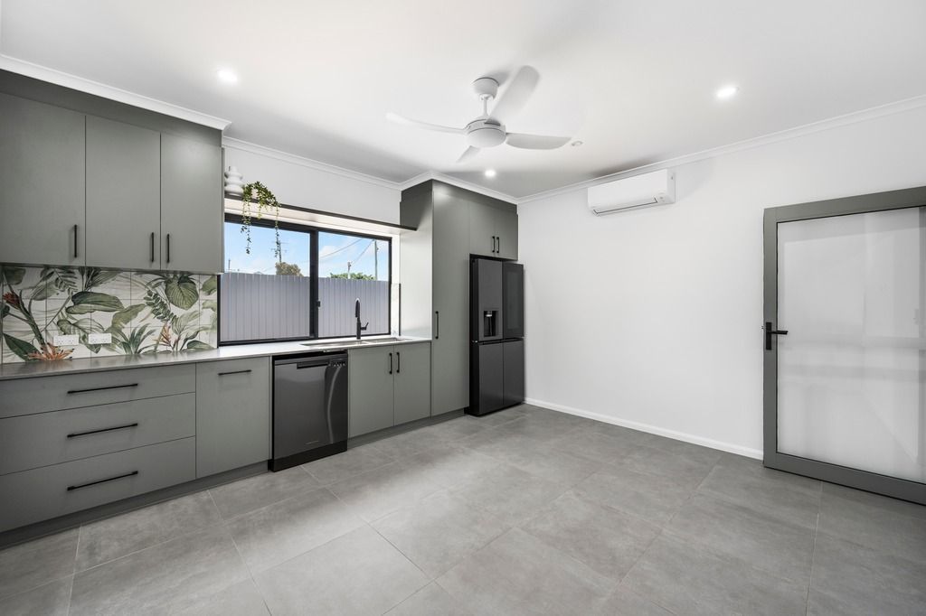 Modern kitchen with gray cabinets, stainless steel appliances, and large window — Construction Company in Townsville, QLD