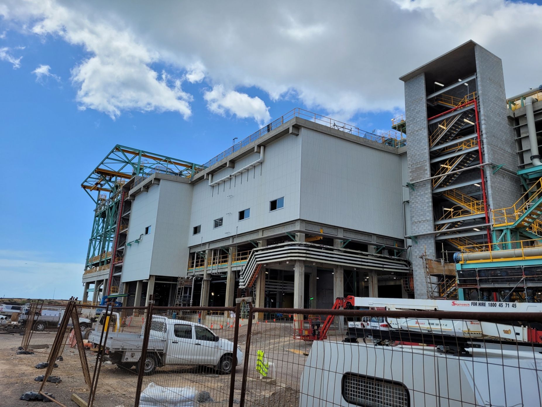 Construction site with a large, light-colored industrial building under construction, blue sky background — Construction Company in Townsville, QLD