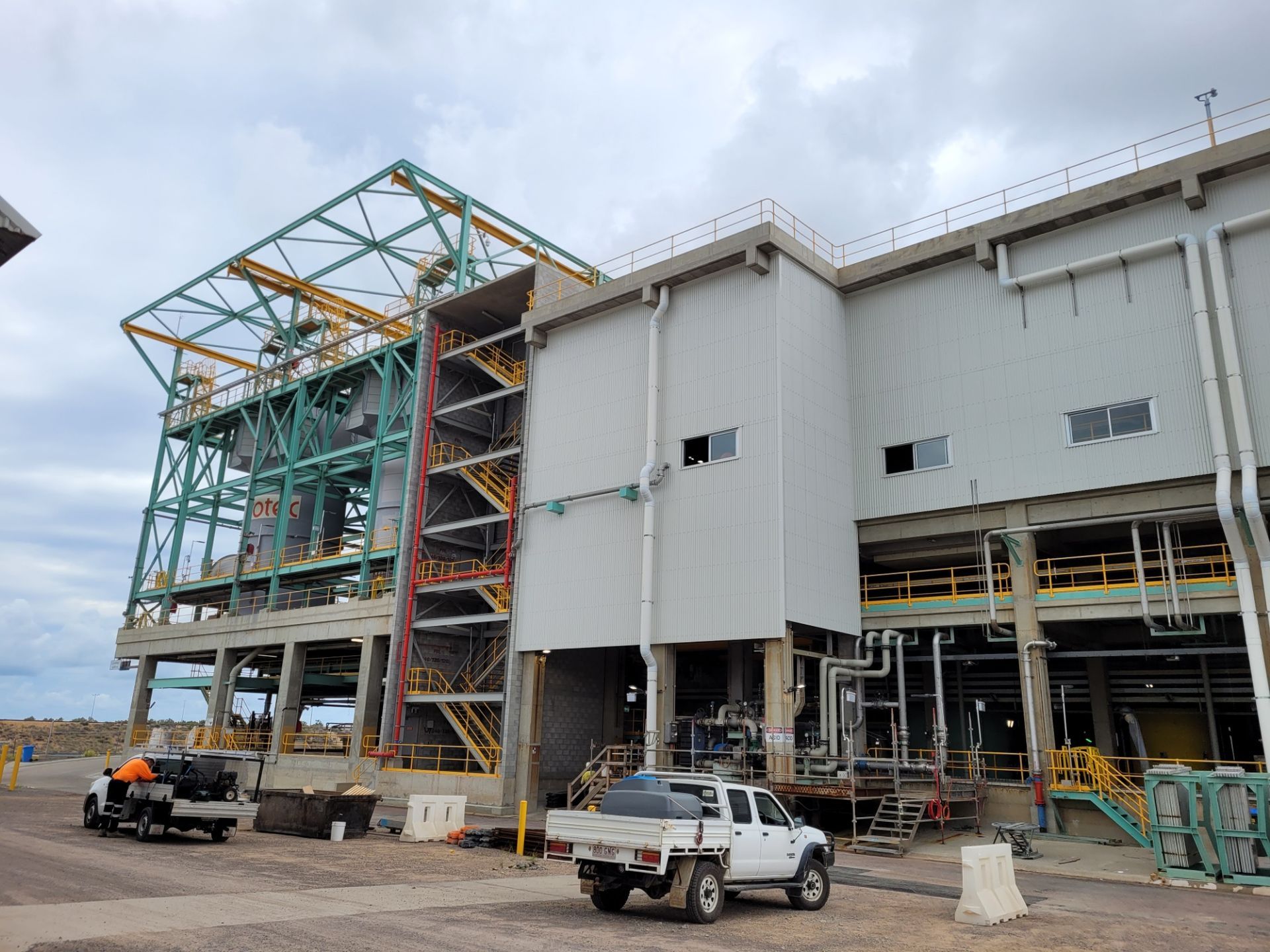 Industrial facility with green metal framework and white building — Construction Company in Townsville, QLD