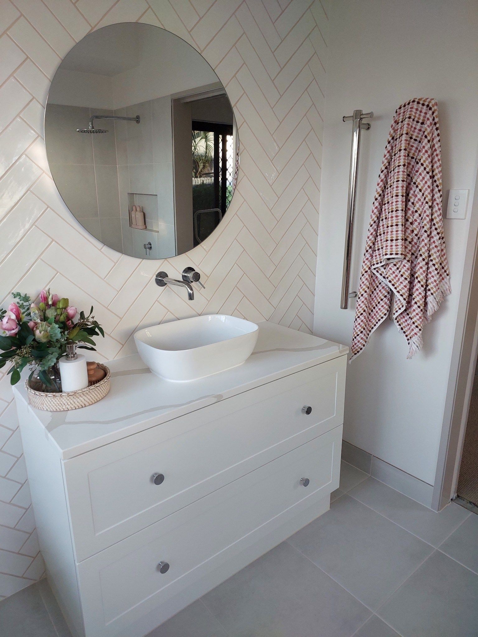 White bathroom with round mirror, vessel sink, and a white dresser as a vanity — Construction Company in Townsville, QLD