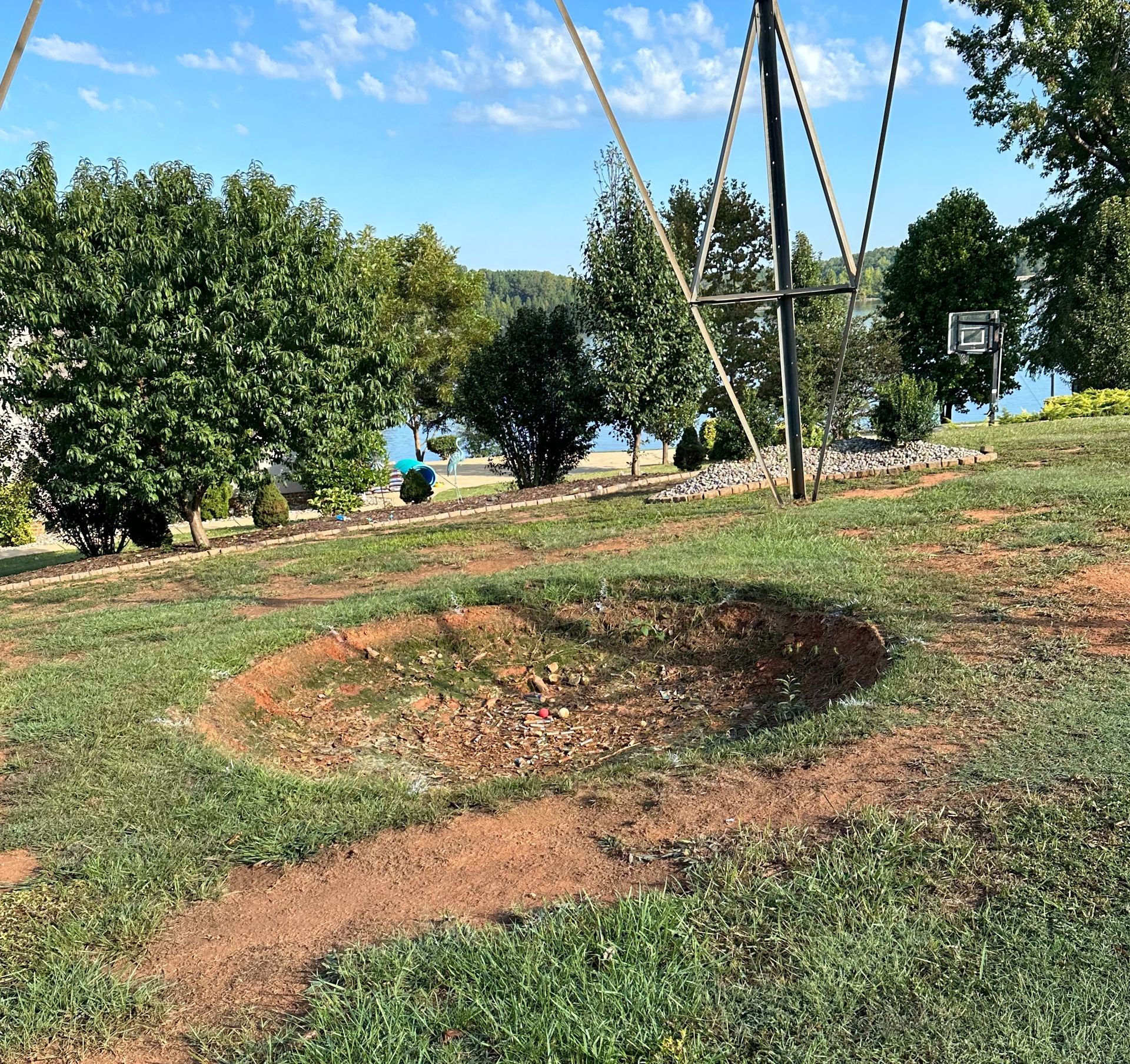 A basketball hoop is in the middle of a grassy field