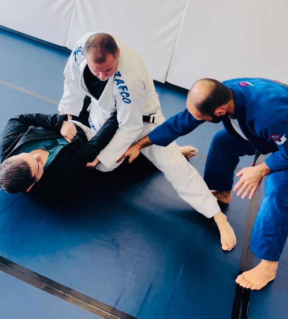 Adults learning BJJ fundamentals with coach