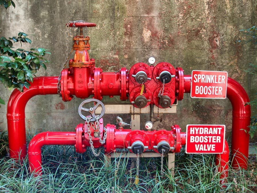 A Red Pipe with A Sign that Says Sprinkler Booster and Hydrant Booster Valve — Fireline 2000 Fire Equipment Pty Ltd in Browns Plain, QLD