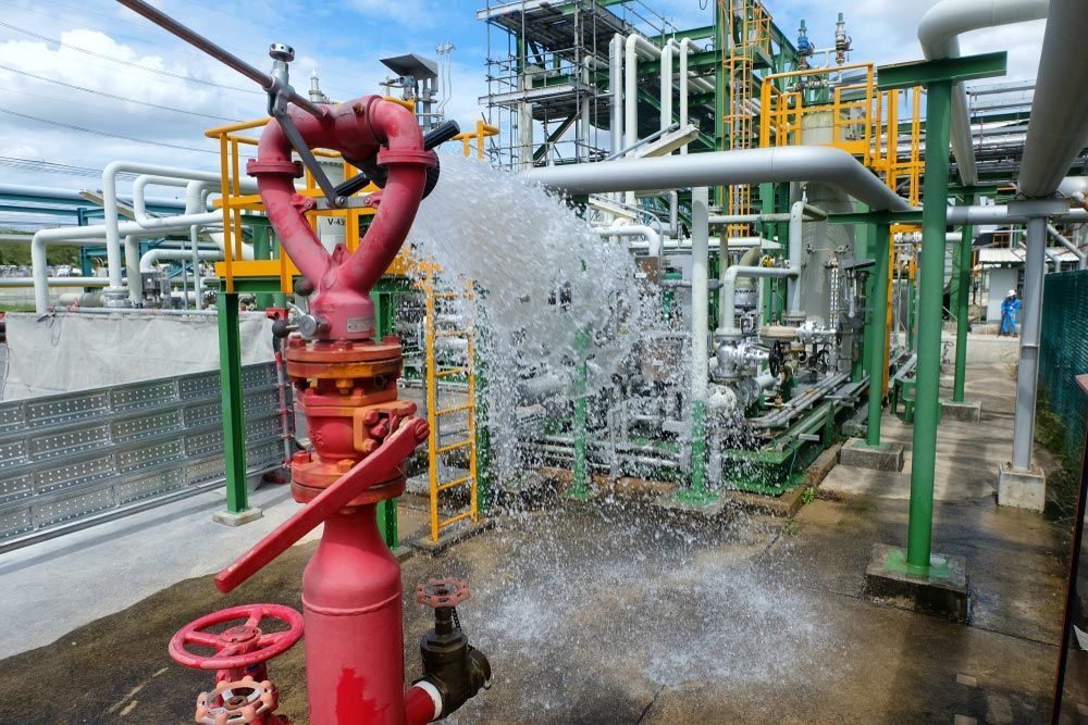 A Red Fire Hydrant Is Spraying Water in A Factory — Fireline 2000 Fire Equipment Pty Ltd in Browns Plain, QLD