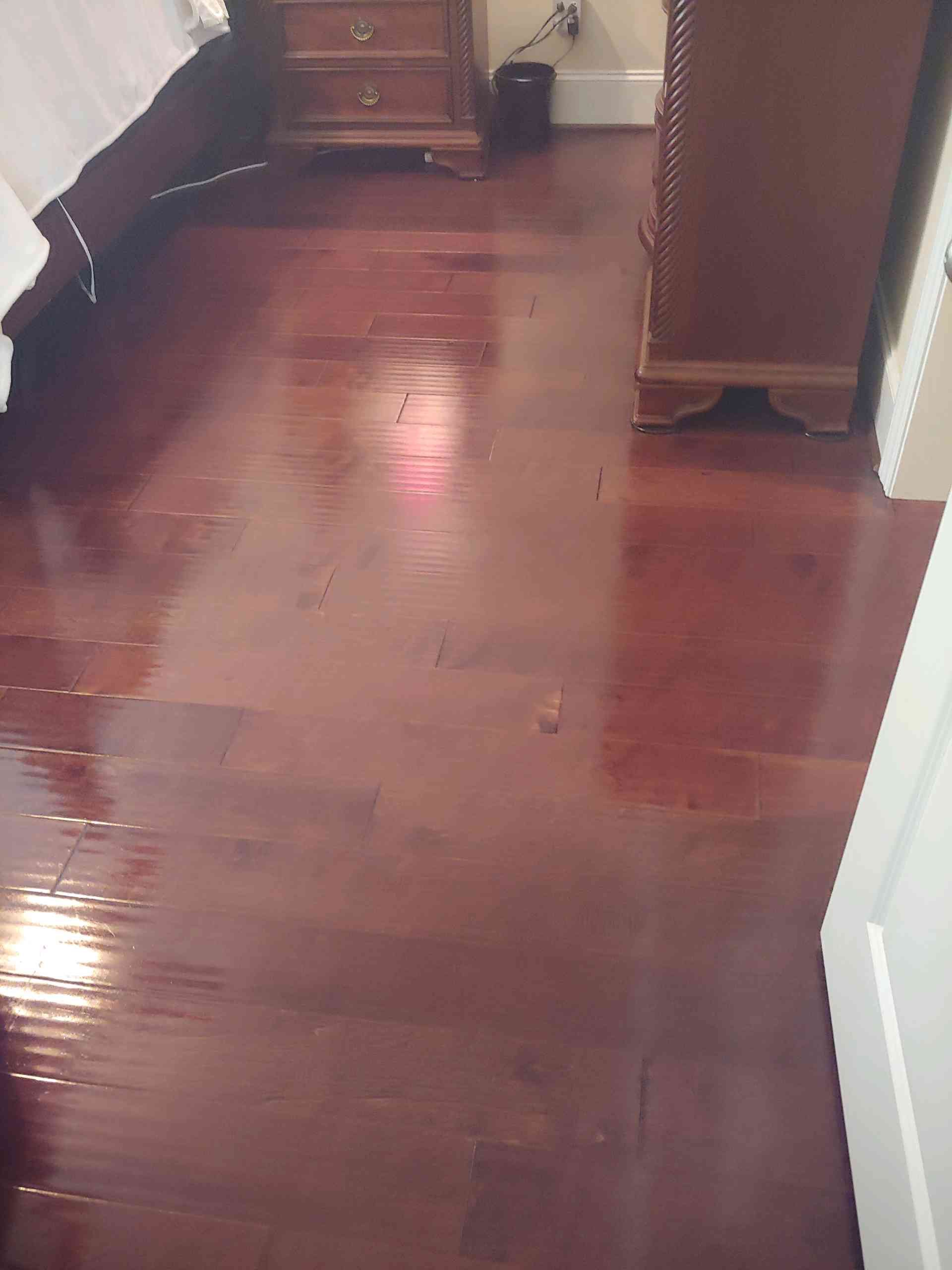 A bedroom with a wooden floor and a bed.