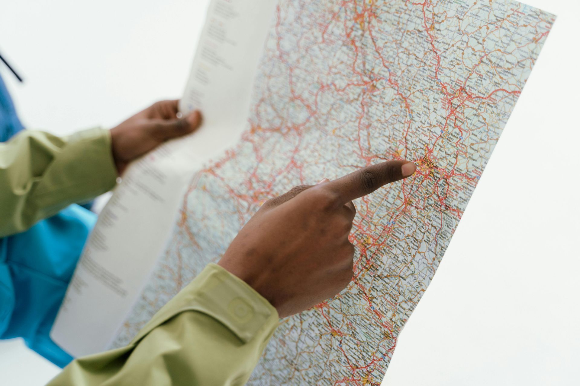 Hands pointing at a detailed road map with red and black routes