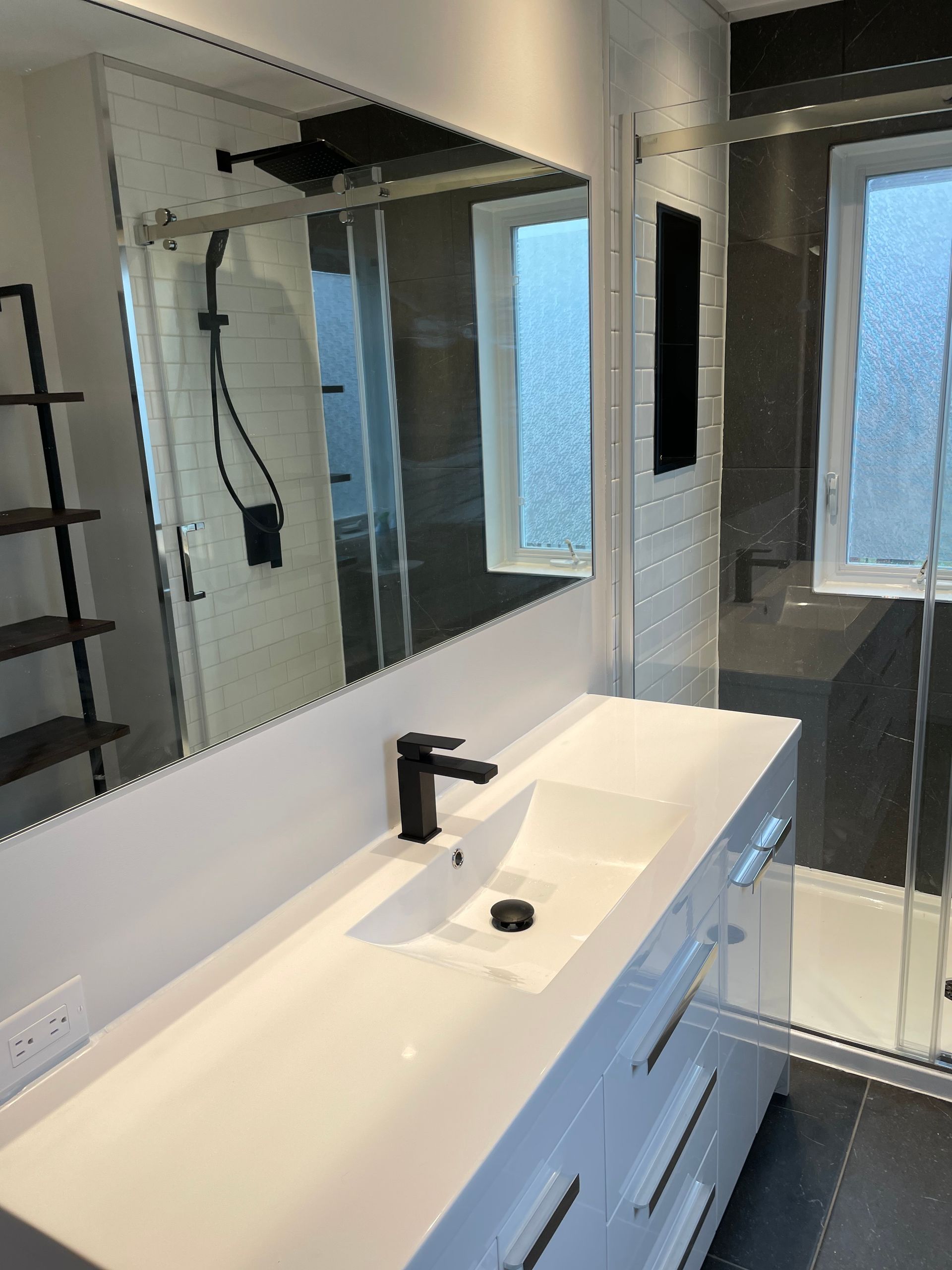 Une salle de bain avec lavabo , miroir et douche.