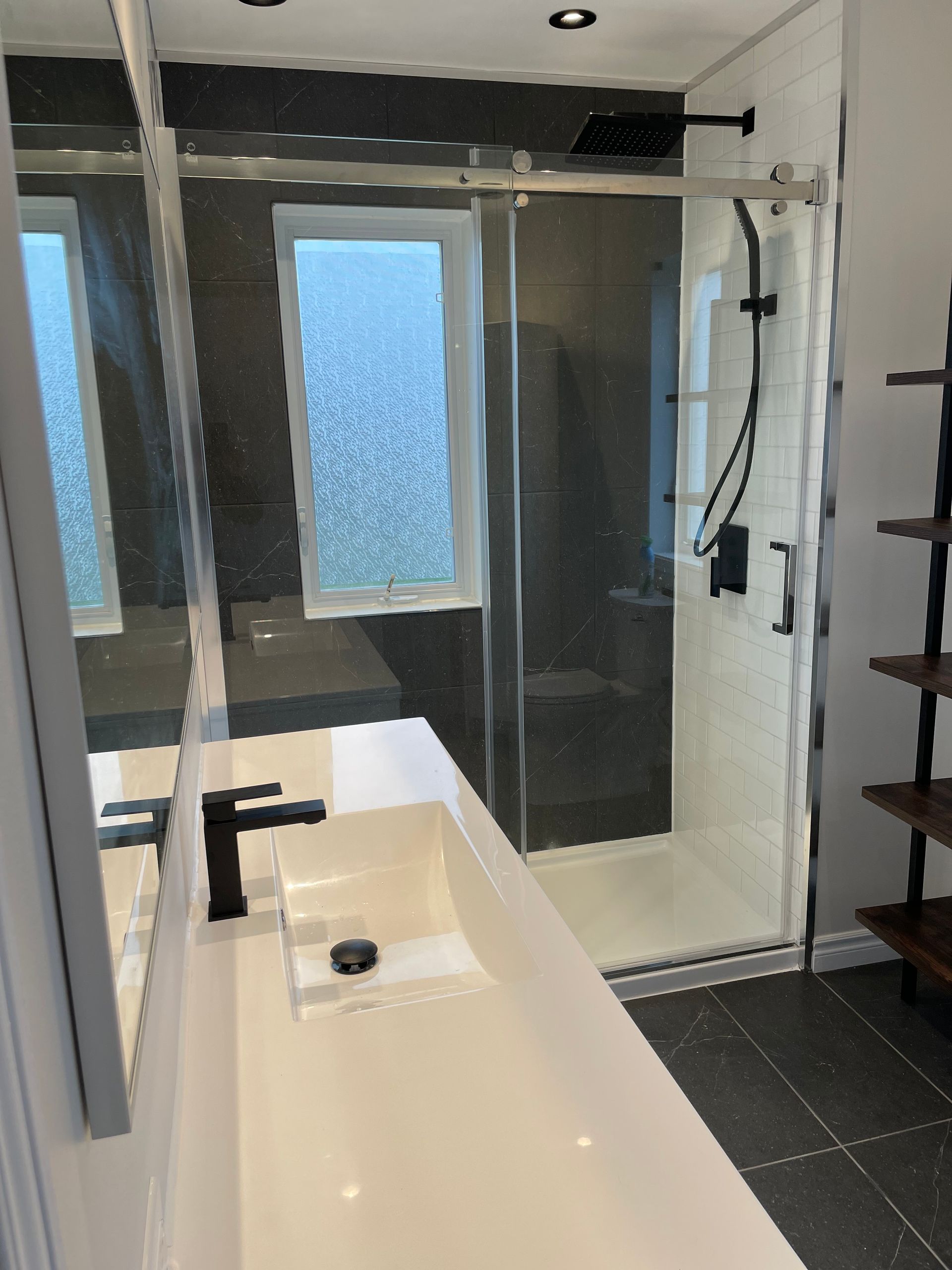 Une salle de bain avec lavabo , douche et miroir.