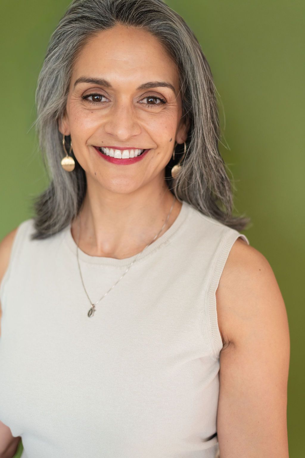 Close up of Judith Watkins with a sleeveless blouse and gold earings
