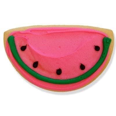 A watermelon cookie with pink frosting and green seeds on a white background.