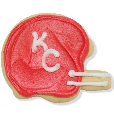 A cookie in the shape of a football helmet with kc written on it