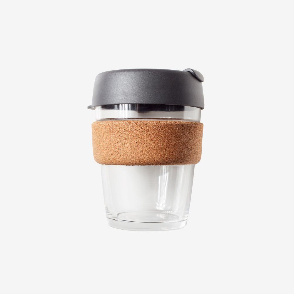 A clear glass coffee cup with a cork handle and lid.