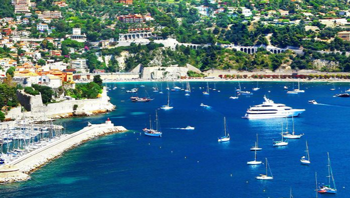 An aerial view of a city at night with a body of water in the background.
