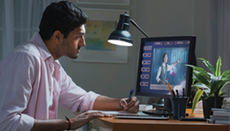 A man is sitting at a desk working on a computer.