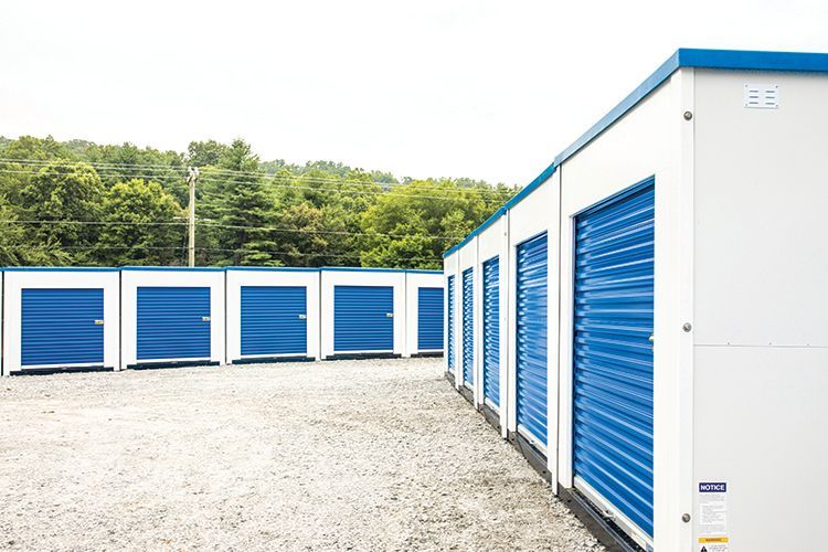 a row of blue and white storage units in a parking lot .
