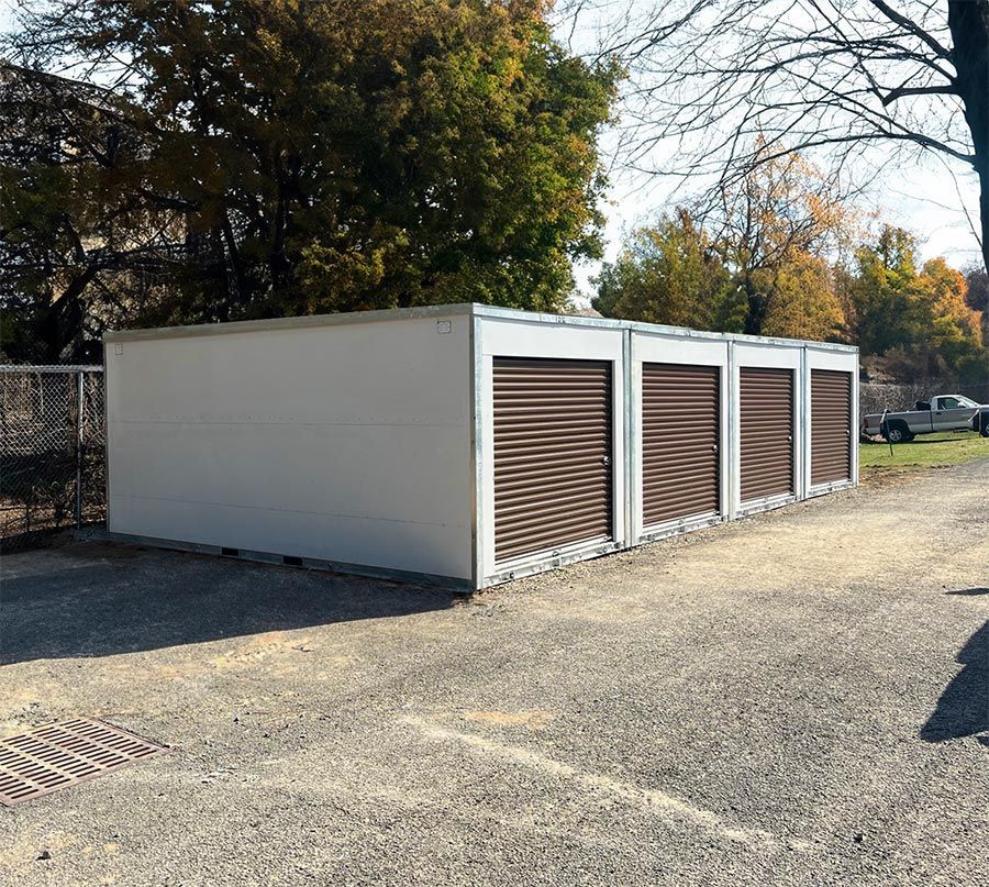 a row of storage units with brown doors in a parking lot