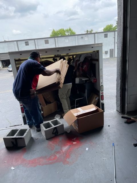 A man is loading boxes into a truck in a garage