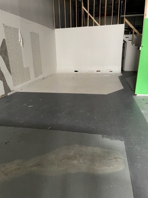 An empty room with a green door and white walls