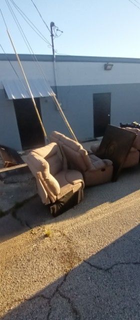 A row of chairs are sitting on the sidewalk in front of a building.