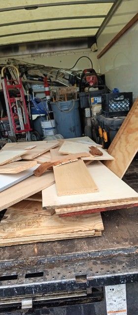 A pile of wood is sitting on the back of a truck.