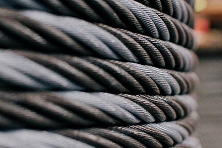 Cable de acero enrollado, fuertemente enrollado, con tonos alternados de gris y negro.