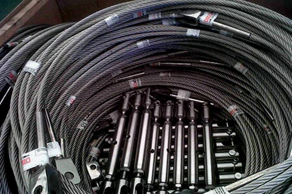 Cables de acero enrollados y tensores metálicos en un entorno de almacenamiento o depósito.