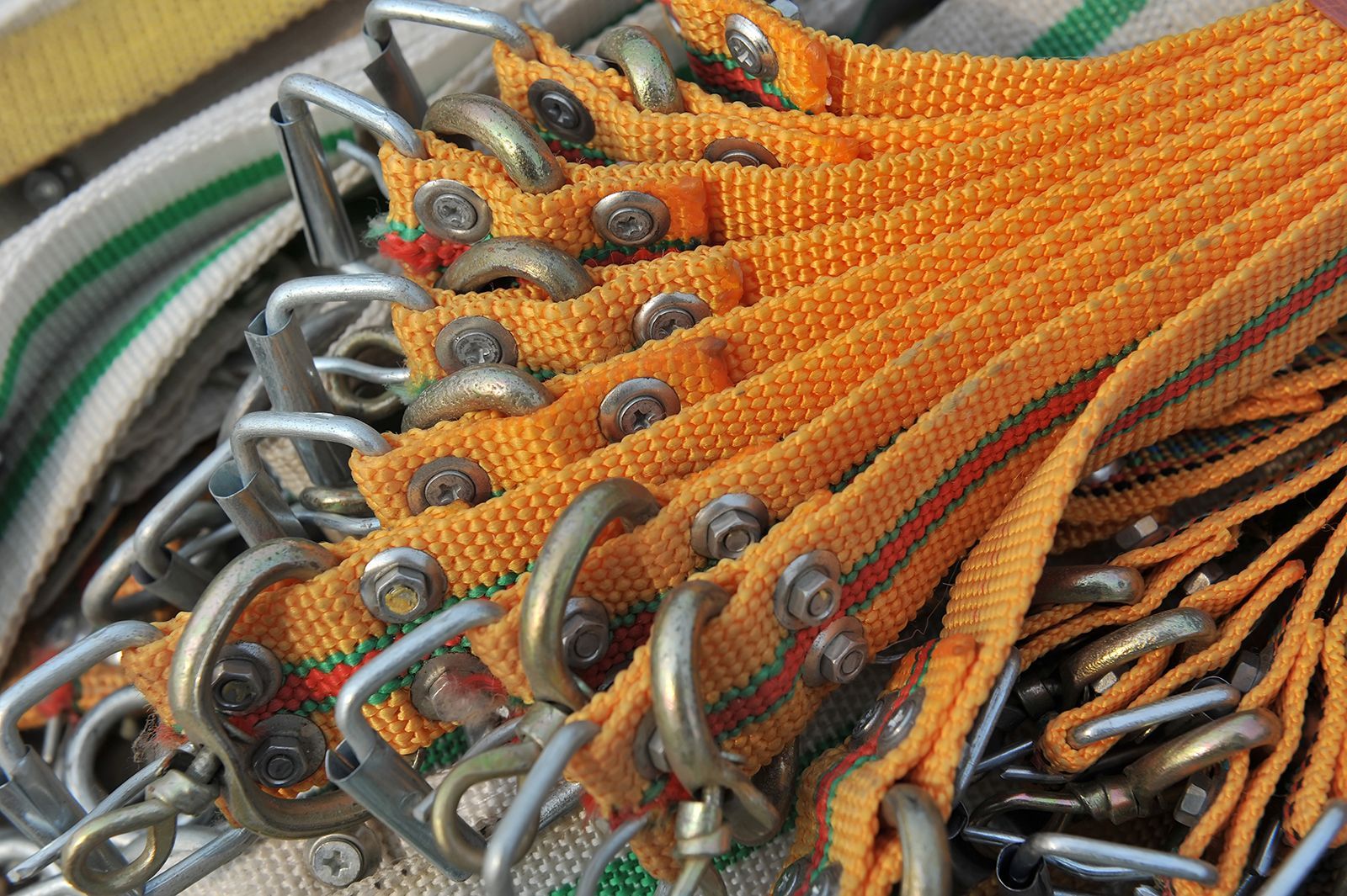 Correas de tela de color amarillo y rojo con ganchos de metal, bien atadas.