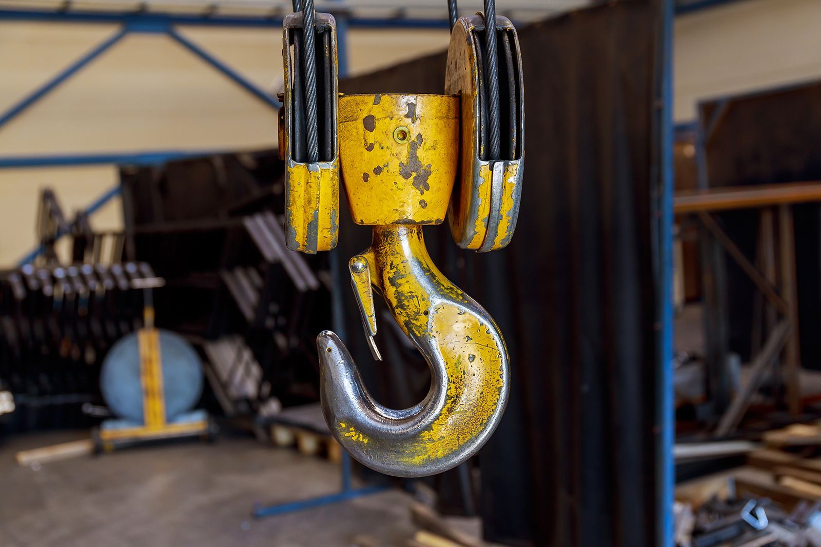 Gancho de grúa industrial de color amarillo y gris, para colgar.