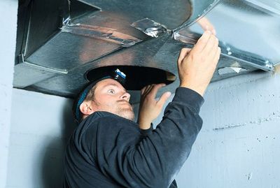 Man Checking Air Duct — Waterford Township, MI — Sutton & Son's Mechanical Inc