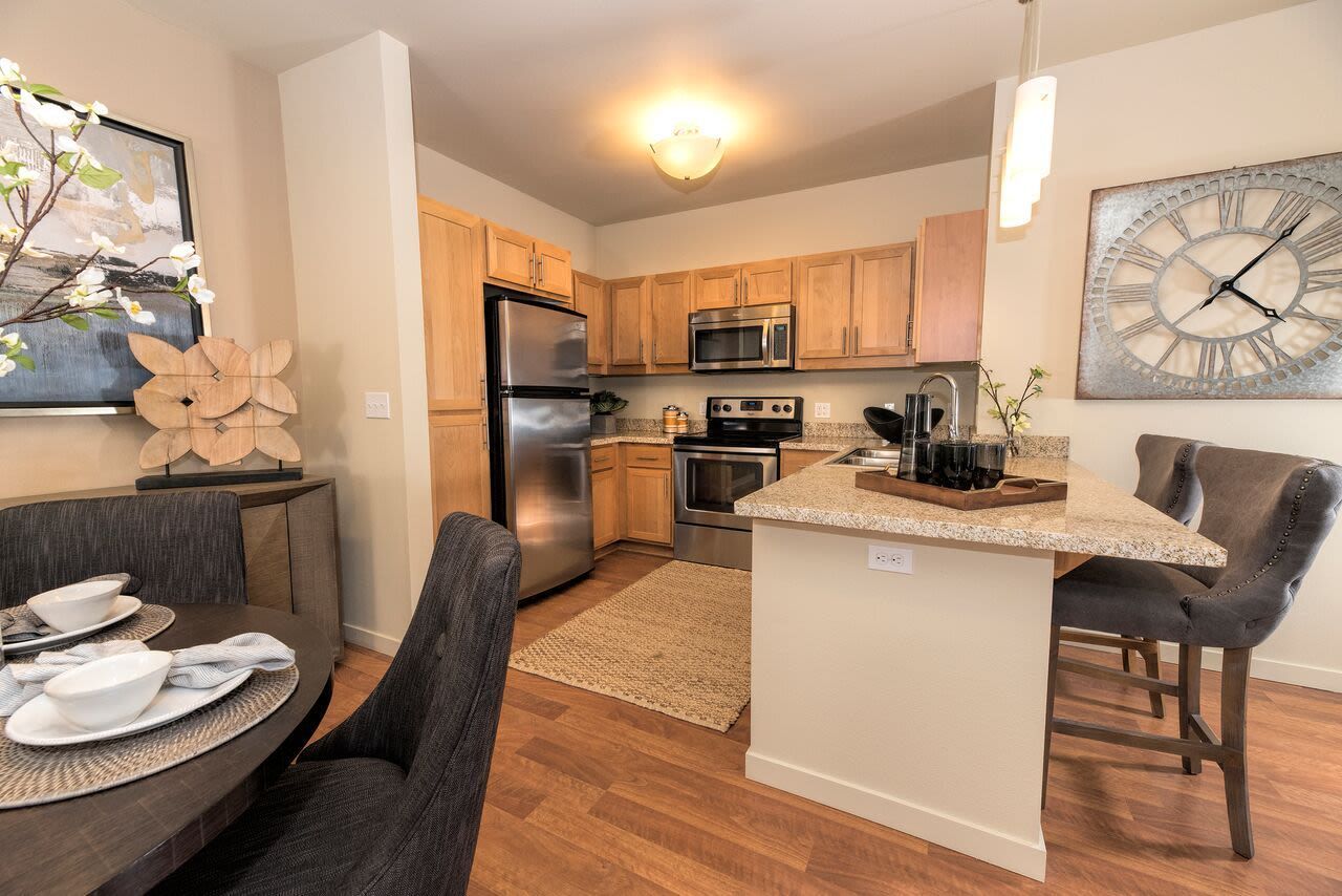 Open-concept kitchen with granite countertops, stainless steel appliances, and island seating.