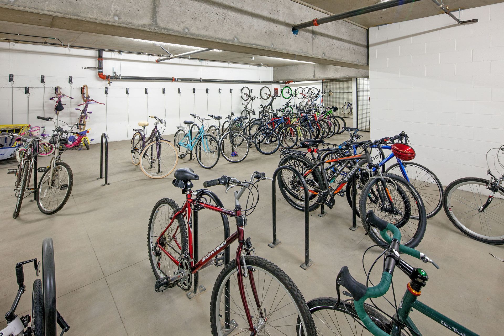 Underground bike storage room with numerous bicycles and racks.